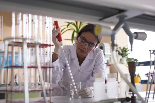 Teenage female university student practicing experiment