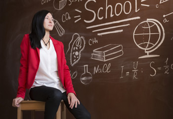 Fototapeta premium teacher at the blackboard on the chair