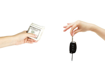 Holding hands with car keys and stack of dollars on white background.