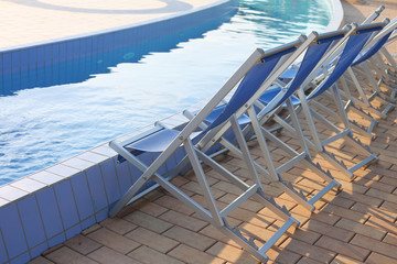 Empty deck chairs on the pool edge of the spa