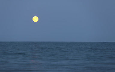 red full moon on the horizon over the sea