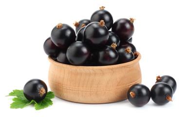 black currant in wooden bowl with green leaf isolated on white background