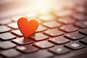 Small red heart on keyboard. Internet dating concept. - obrazy, fototapety, plakaty