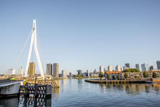 Landscape view on the riverside with beautiful buildings and modern bridge during the morning in Rotterdam city