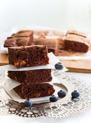 Stack three square pieces of homemade chocolate brownies and blueberries. Dark Chocolate cake with...
