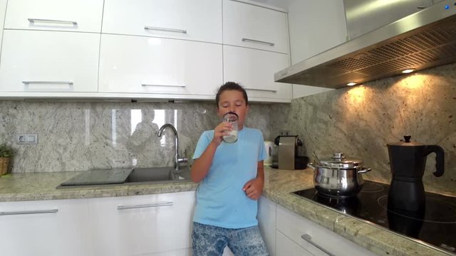 Portrait of a teenage boy drinking milk in the kitchen
