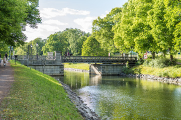 Den gamla och vackra Djurgårdsbrunnsbron som passerar över Djurgårdsbrunnskanalen en varm sommardag