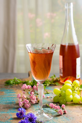 Cold summer rose wine, served in beautiful glass on terrace in cafe with romantic flowers