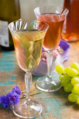 Cold summer wines, white and rose, served in beautiful glasses on terrace in cafe with romantic flowers