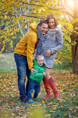 Naklejka na ściany i meble Happy family playing in autumn park