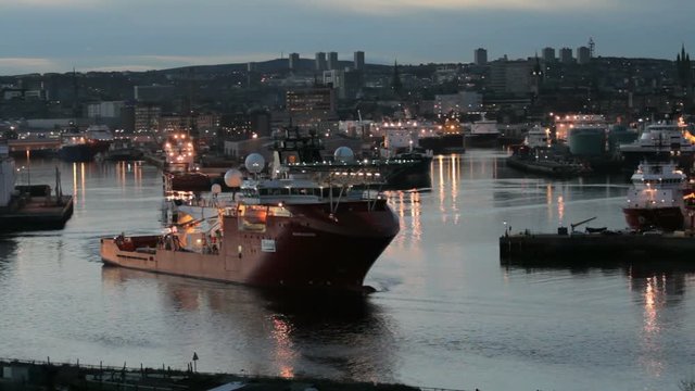 Oil rig support vessel leaving Aberdeen Harbour at dusk