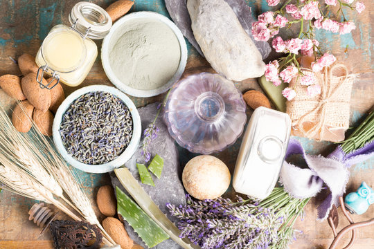Nature cosmetics, handmade preparation with essential oils and ancient minerals of  parfums, creams, soaps from fresh and dried lavender and roses flowers, wheat, almond nuts top view 