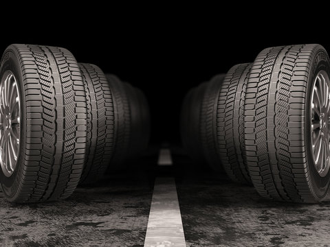 Car tires standing on the road on black background.