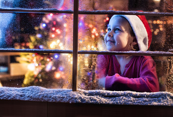 On Christmas night a lovely little girl looking out the window © jackfrog