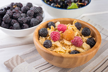  Breakfast with muesli, blackberries and raspberries,  bowl of corn flakes with berries and milk