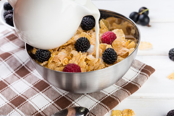 Healthy breakfast,  bowl of corn flakes with berries and milk