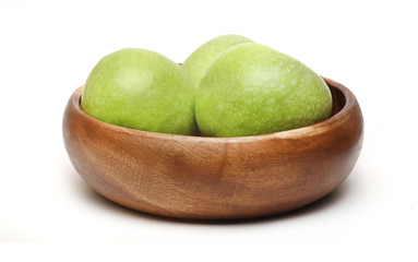 green apples in a bowl on a white background