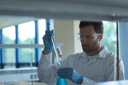University student doing a chemical experiment in laboratory