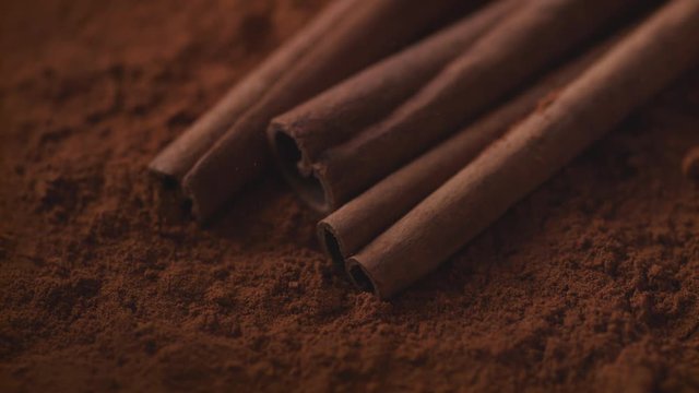 Cinnamon sticks falling into cinnamon powder. Shot with high speed camera, phantom flex 4K. Slow Motion.