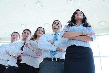 Smiling and confident business team standing in front of a bright