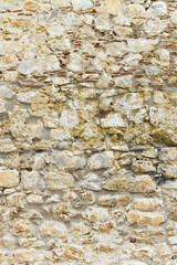 Wall built of stone (tufa, limestone) and mortar; fence, tower, fortress; background, texture.