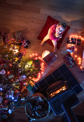 top view. Christmastime. A little girl near the Christmas tree