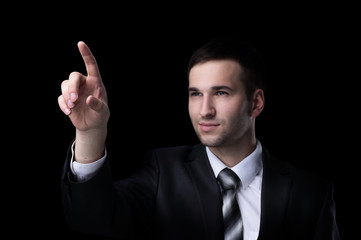 Business man pressing an imaginary button. Isolated on black.