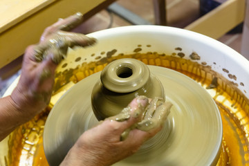 A pottery. Master on the circle makes a vase of clay.