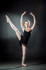Ballerina. Cute little girl posing and dancing in studio. The girl is studying ballet.
