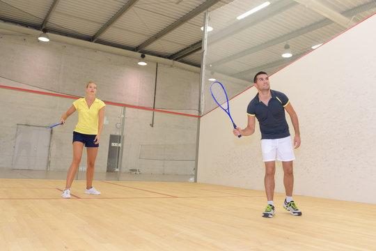 couple playing at an indoor tennis court