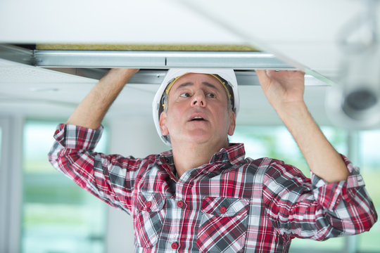 worke installing ceiling in building