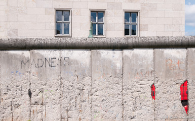 Memorial remains of the Berlin Wall wuth the word MADNESS 