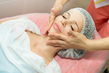Obraz na płótnie Canvas beautiful young girl on a facial massage procedure in a beauty salon