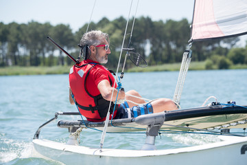 man sailing with sails out on a sunny day