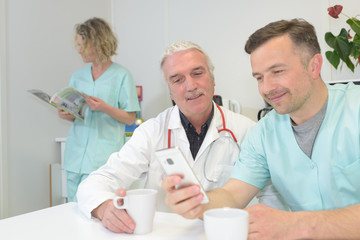 medical doctor with nurses outdoors enjoying coffee break