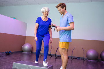 coach showing the timer for the elderly woman