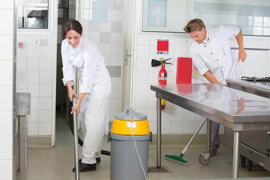 kitchen aids are cleaning the restaurant kitchen