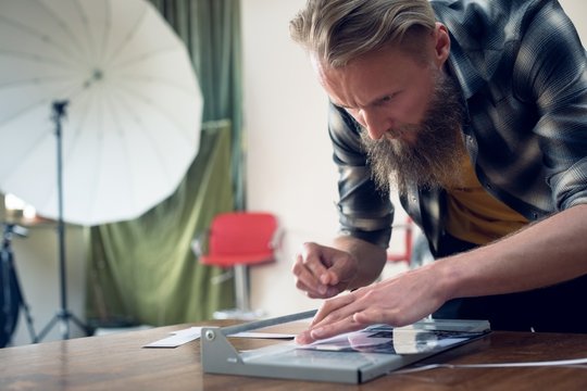 Close up of photographer cutting photograph on paper cutting