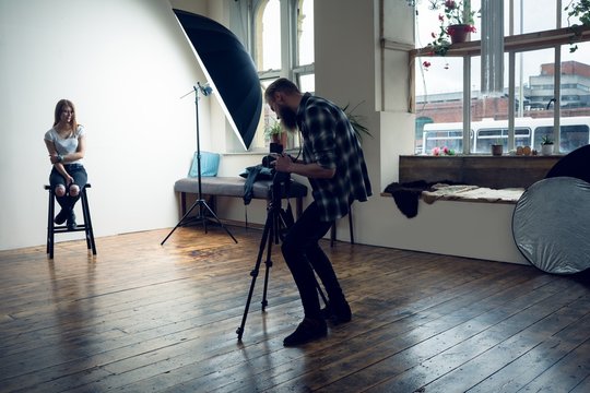 Photographer taking pictures of a fashion model in the studio