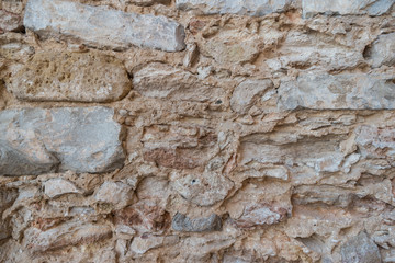 Stone wall of old limestone stones. Abstract texture