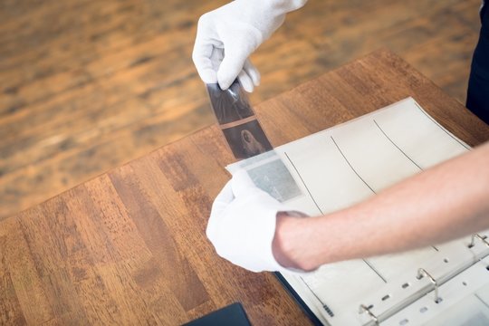 Cropped hand of photographer putting film in folder
