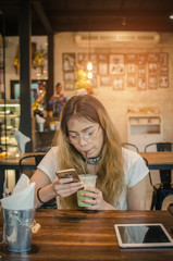 girl using tablet on wooden table in cafe