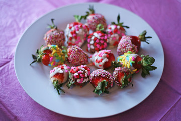 Iced strawberries dipped in multicoloured treats