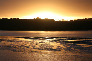 Naklejka premium Sun sets across the coastal estuary near the Bay of Islands, on New Zealand's North Island