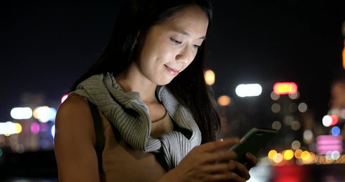 Woman using smart phone in Hong Kong at night