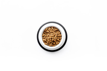 bowl full and overflowing with dry pet - cat food bits on white background top view mock-up