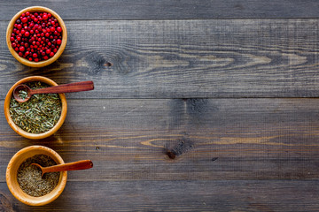 Variety of spices and dry herbs in bowls on wooden kitchen table background top view mock-up