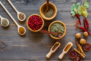 Colorful dry herbs and spices for cooking food wooden kitchen table background top view
