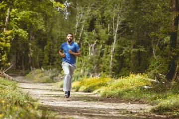 Young man jogging on road in forest