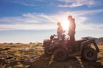 Rear view of young pair near atv. Man is showing something in distance to her girlfriend. © FS-Stock